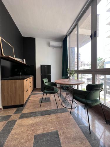 都拉斯Cactus Apartments的客厅配有桌椅和大窗户
