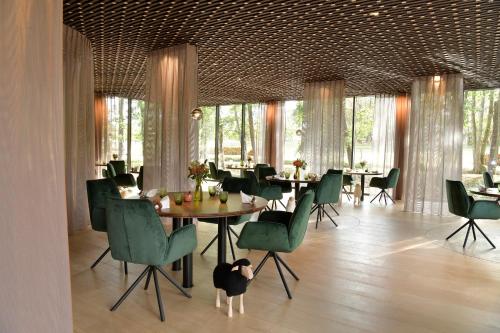 沃德吕尼鲁尼跳马城堡酒店的用餐室配有桌子和绿色椅子
