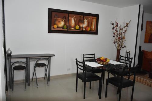 波哥大ApartaHotel Modelia con Parqueadero的用餐室配有桌椅和墙上的照片