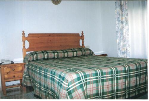 巴达霍斯Hostal Niza的一间卧室配有一张带拼接棉被的床