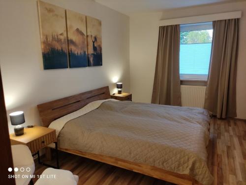 Imsterberggroassehof Haus Gstrein的一间卧室设有床、两张桌子和一扇窗户