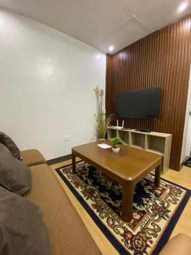 MarilaoFlores Staycation的客厅配有咖啡桌和电视