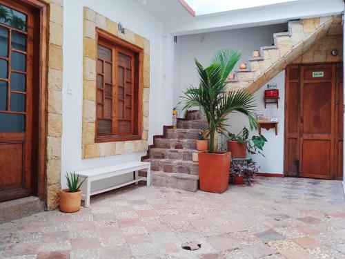 波哥大Casita de Piedra的隔壁有楼梯和盆栽植物的房子