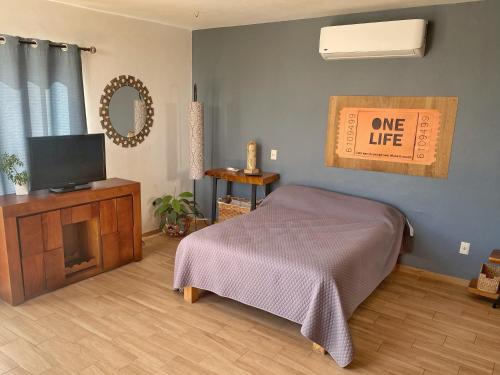 Santa AnitaExclusivo Loft en Santa Anita的一间卧室配有一张床、一台电视和一个生活标志