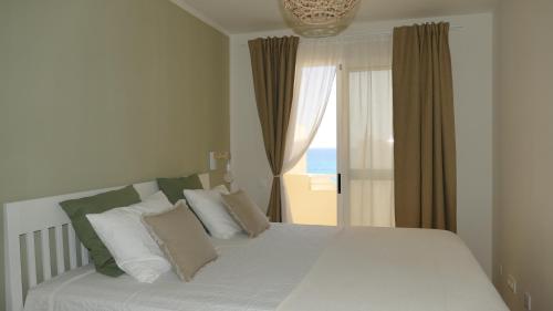 科斯塔卡玛Blue Lagoon Apartment的一间卧室设有一张床和一个海景窗户