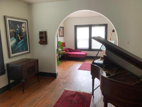 拉法叶Dr. Yaple's Art Deco House的客厅配有钢琴和粉红色的沙发