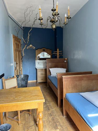 莱比锡地球家园旅舍的一间卧室设有蓝色的墙壁、桌子和两张床