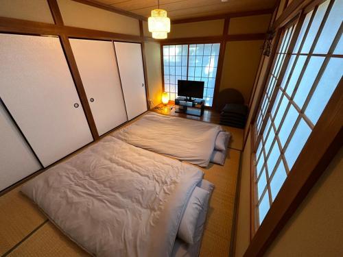 IchigayaShirako House的卧室配有一张床、一张书桌和窗户。