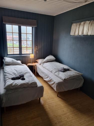 弗勒Stor leilighet med 4 senger sentralt i Førde的一间卧室设有两张床和窗户。