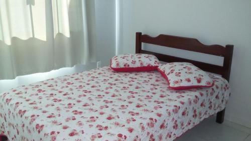 邦比尼亚斯Casa Bombinhas temporada的一间卧室配有一张带两个枕头的床