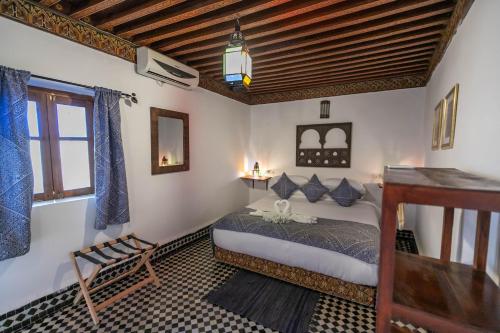 非斯Riad Dar Omar的一间卧室设有一张床和木制天花板