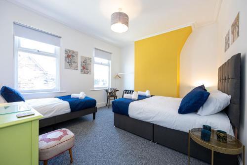 利物浦Air Host and Stay - Earp House 3 bedroom, sleeps 7, mins from train的一间卧室配有两张床、一张桌子和一张桌子