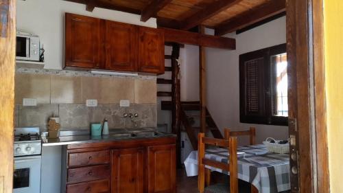 圣罗莎卡拉穆奇塔县POSADA LAS MARGARITAS的厨房配有木制橱柜、桌子和楼梯。