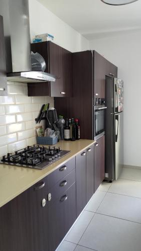 哈德拉Green Park的厨房配有棕色橱柜和黑色冰箱