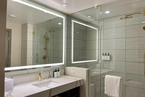 拉斯维加斯Elegant Stay at Resorts World Strip Las Vegas的一间带水槽和玻璃淋浴的浴室