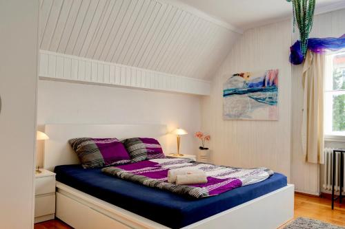卡塞尔Wohnung am Bergpark Wilhelmshöhe的一间卧室配有一张带紫色床单的大床