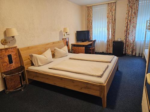 沃尔姆斯Hotel City Faber的一间卧室配有一张床和一张书桌