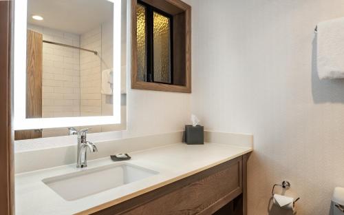 戈尔德比奇Gold Beach Inn的一间带水槽和镜子的浴室