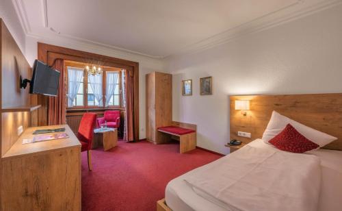 里拉辛根-沃布林根克朗酒店的配有一张床和一张书桌的酒店客房