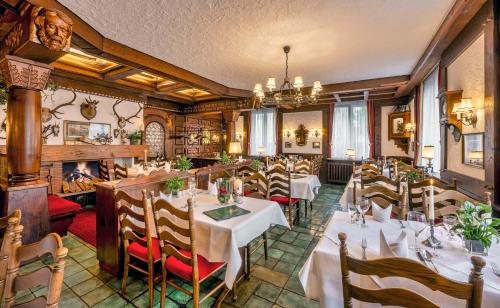 里拉辛根-沃布林根克朗酒店的一间带桌椅和壁炉的餐厅