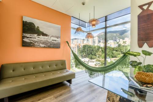 麦德林哥伦比亚十级酒店 的带沙发和大窗户的客厅