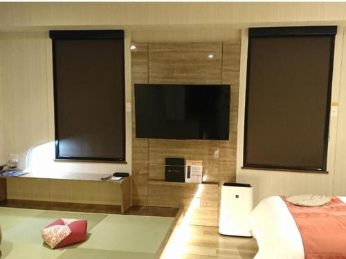 千岁QUEEN'S HOTEL CHITOSE - Vacation STAY 67739v的一间卧室设有平面电视和一张床。