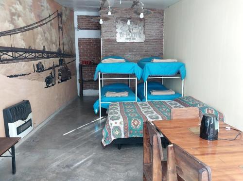 波特雷罗德洛斯弗内斯Hostel el Tata的客房设有两张双层床和一张桌子。