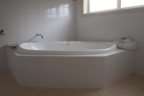 佩诺拉亚历山大卡梅隆套房汽车旅馆的带窗户的浴室内的白色浴缸