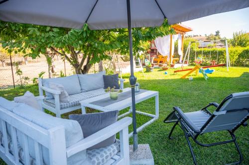 卡兰兹拉Villa Marina的庭院配有桌椅和遮阳伞。