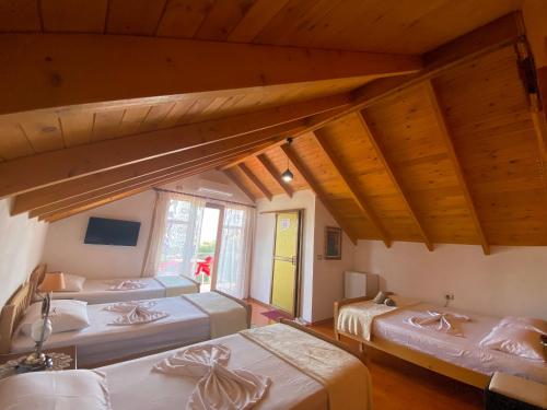 吉诺卡斯特Bixhaku GuestHouse的带木天花板的三张床