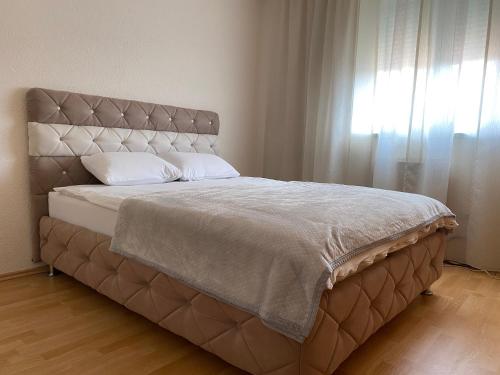 Bosanski ŠamacApartman MARIJA的一张带大床头板和窗户的床