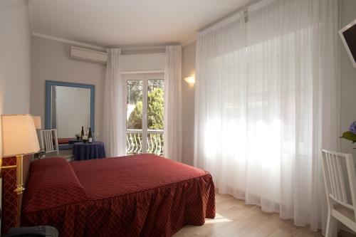 拉帕洛埃尔加托酒店的一间卧室设有红色的床和窗户。