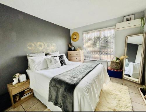德班Makwande Self-Catering Apartment的一间卧室设有一张大床和一个大镜子