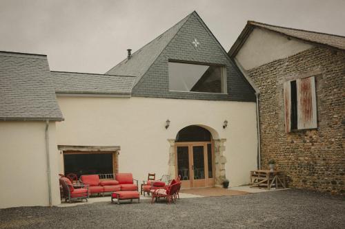 莫南Domaine de Berducq的一座带红色椅子的房子和一座建筑