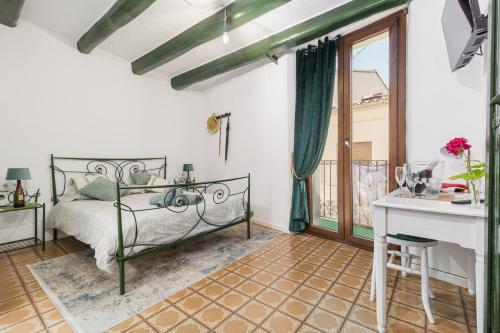 PieraLa Casa Vella EL BEDORC的一间卧室配有一张床、一张书桌和一个窗户。