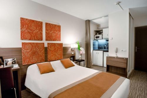 尚贝里凯拉迪尚贝里中心住宿酒店的一间带白色大床的卧室和一间厨房