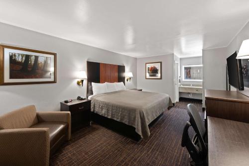 格罗夫城贝斯特韦斯特行政酒店的配有一张床和一把椅子的酒店客房