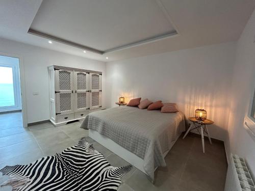 圣乌尔苏拉Casa Anna的白色卧室配有一张床和斑马地毯