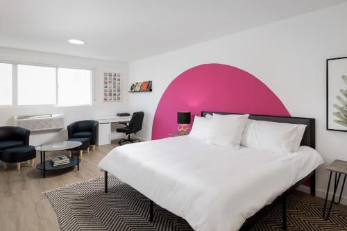 洛杉矶Fenix Hotel Hollywood的一间卧室设有一张大床和粉红色的墙壁