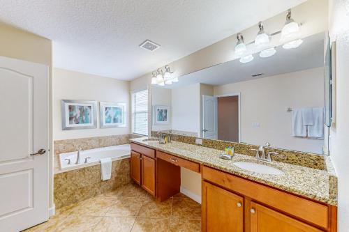 基西米Cool in Kissimmee的浴室配有2个盥洗盆、浴缸和镜子