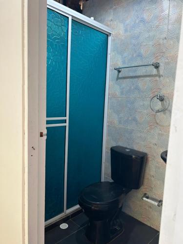 Playa Punta ArenaEco-Conscious Oasis Punta Arena 01的浴室设有黑色厕所和蓝色的墙壁