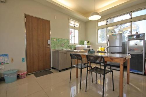 金宁乡金门幸福树舍背包客栈民宿的厨房配有桌椅和冰箱。