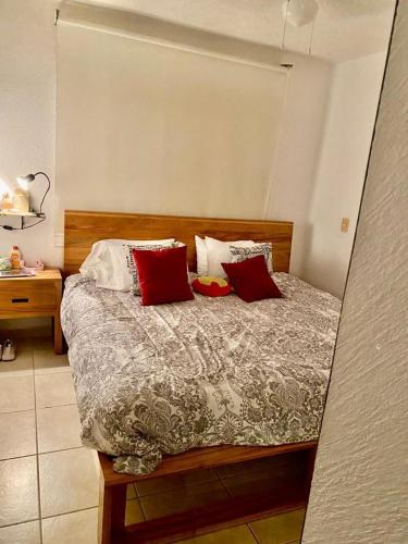 阿卡普尔科Casa Puko的一间卧室配有红色和白色枕头的床