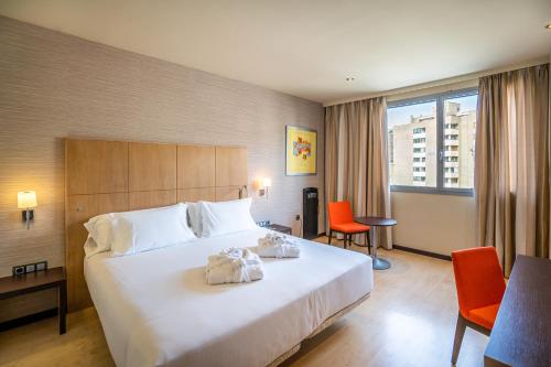 韦斯卡阿巴韦斯卡酒店的酒店客房带大型白色床和橙色椅子