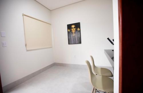 RedençãoCapuzzo Flat 2的白色的房间,配有椅子和墙上的照片