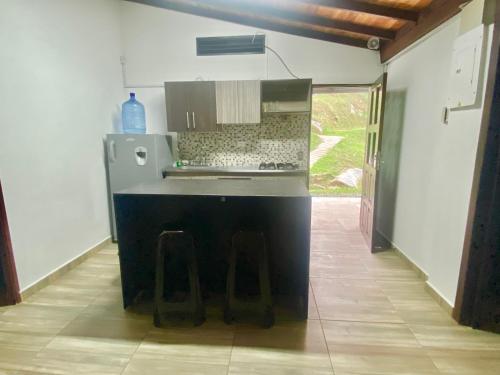 瓜塔佩Eros Hostel & Brunch的一间厨房,内设一个柜台和凳子