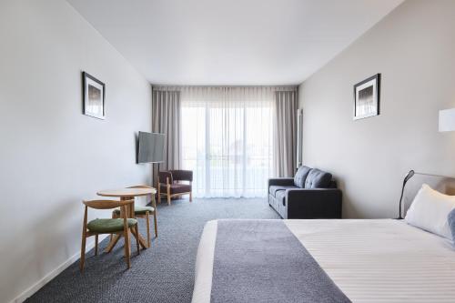 堪培拉甘加林 公寓的酒店客房配有床、沙发和桌子。