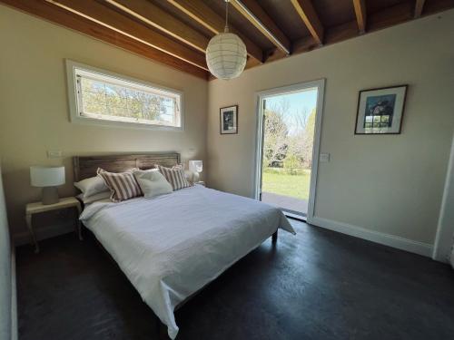 EwingsdaleSunset Cottage, Byron Bay的一间卧室设有一张大床和一个窗户。