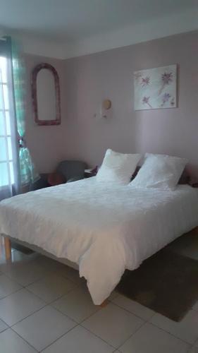 Arthez-de-BéarnO'jardin的卧室内的一张带白色床单和枕头的床
