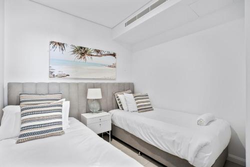 黄金海岸Ocean Surfers Paradise - GCLR的白色墙壁客房的两张床